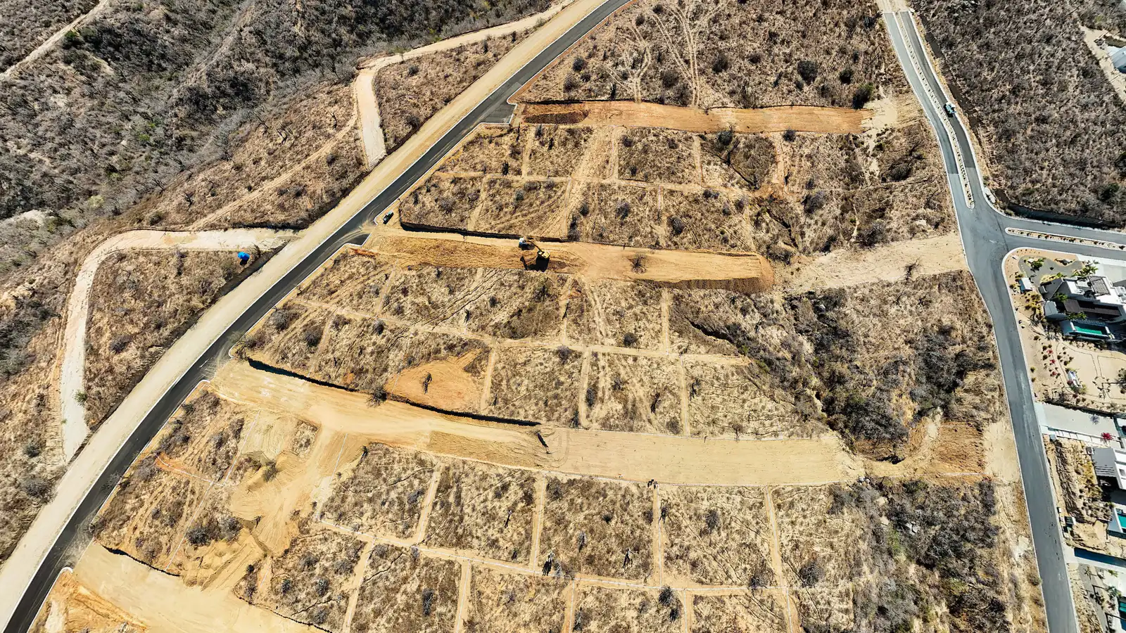 Vista aérea real de un desarrollo con cada lote trazado y marcado como disponible, reservado o vendido